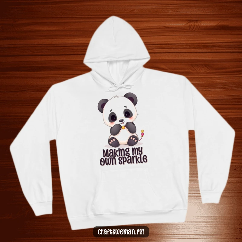 Funny hoodie with a playful panda meticulously stringing beads with its paws, perfect for cozy crafting.