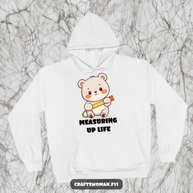 Funny bear using a tape measure, looking determined, on a cozy hoodie, perfect for builders and DIY lovers.